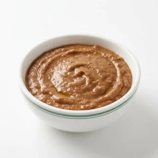 Refried Beans, a bowl of refried beans on a clean light surface